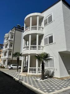 a large white building with palm trees in front of it at Villa Del Sol in Golem