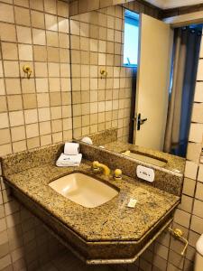 a bathroom counter with a sink and a mirror at Hotel Teofilo Otoni in Teófilo Otoni +25 photos