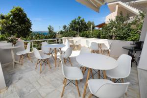 a patio with white tables and chairs on a balcony at Villa Christianna Free Parking in Vlorë