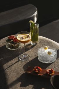 a table with a drink and some food on it at Kivotos Santorini - Preferred Hotels & Resorts in Imerovigli