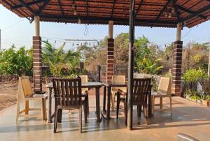a wooden table and chairs on a patio at Samarpit Guest House in Devgarh