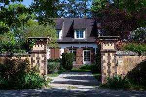 a house with a gate and a driveway at Gites de Coulonge in Coulonges-Ardennes