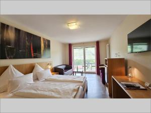 ein Hotelzimmer mit Bett und Schreibtisch in der Unterkunft Christiana's Wein & Art Hotel in Bernkastel-Kues