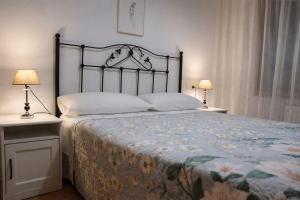 a bedroom with a large bed with two lamps at Apartamento Alfa in Monforte de Lemos