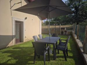 ein schwarzer Tisch und Stühle mit einem Sonnenschirm in der Unterkunft Checoira in Ourense