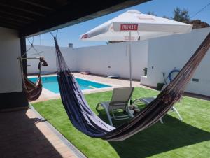 a hammock and an umbrella next to a pool at Casa dos Avós in Mértola