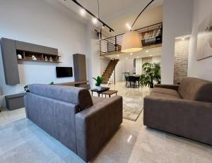 a living room with two couches and a dining room at Loft43 in Trani