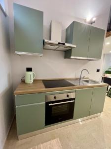 a kitchen with green cabinets and a sink at Loft43 in Trani +10 photos