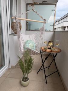 a hammock on a balcony with a table and wine glasses at Premium Apartment in Peje