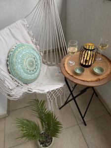 a hammock chair with a table and glasses of wine at Premium Apartment in Peje