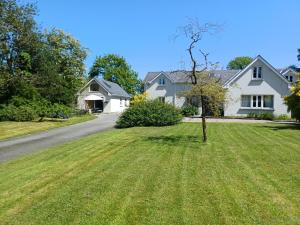 a house with a tree in the middle of a yard at Stable Lodge in Killarney