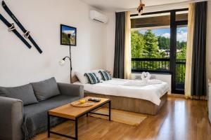 a living room with a bed and a couch at Edelweiss Studio - Aspen Valley in Razlog