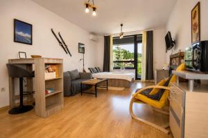 a living room with a couch and a bed in a room at Edelweiss Studio - Aspen Valley in Razlog