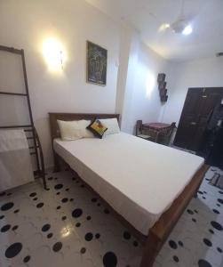 a bedroom with a large white bed in a room at Amith Villa in Koggala