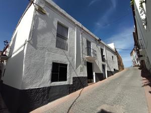 an alley with white buildings on the side of a street at Casa Ameghino in Laujar de Andarax
