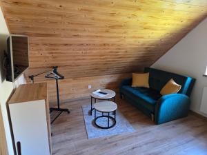 a living room with a blue couch and a table at Domek Lipowy BALIA-jacuzzi in Sasino