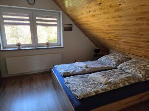 two beds in a room with two windows at Domek Lipowy BALIA-jacuzzi in Sasino