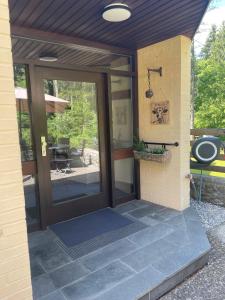 a front door of a house with a patio at Allgäu Bungalow GLOW in Isny im Allgäu
