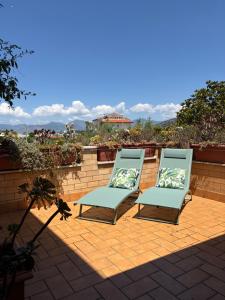 two blue chairs sitting on a brick patio at Casa Noemi in Sperlonga