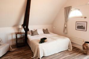 a bedroom with a bed with white sheets and a window at Tunnby Gårdshotell in Nyhamnsläge