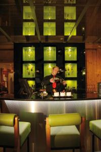 a man standing behind a bar in a restaurant at Loftsuite Hotel Saas in Saas-Almagell