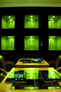 ein Esszimmer mit grüner Beleuchtung und einem Glastisch in der Unterkunft Loftsuite Hotel Saas in Saas-Almagell
