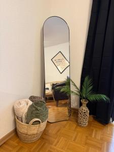 a mirror in a room with a basket and a plant at Premium Apartment in Peje