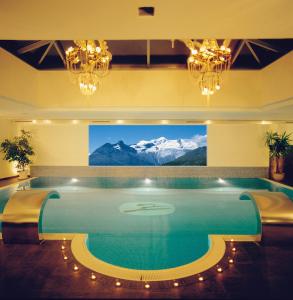 a large swimming pool with a view of mountains at Loftsuite Hotel Saas in Saas-Almagell