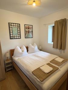a bedroom with a bed with white sheets and pillows at Száka Kőház in Balatonfüred