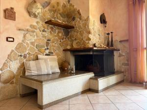 a stone fireplace in a room with a stone wall at Casa Noemi in Sperlonga +27 photos