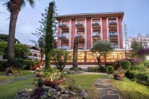 a building with a garden in front of it at Hotel Astoria in Bordighera
