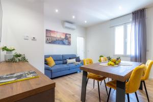 ein Wohnzimmer mit einem Tisch und einem blauen Sofa in der Unterkunft Lamagia in Bologna