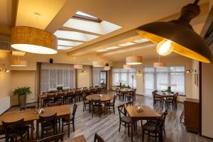 a dining room with wooden tables and chairs at Hotel Slunce - wellness s bazénem, pivovar Morous a bowling in Rýmařov