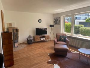 a living room with a chair and a television at Allgäu Bungalow GLOW in Isny im Allgäu