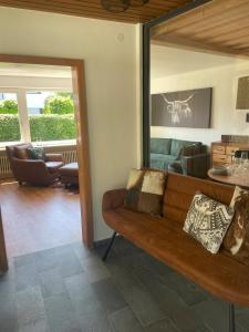 a living room with a brown couch and a table at Allgäu Bungalow GLOW in Isny im Allgäu