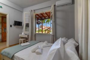 a bedroom with a large bed with a window at Eudokia's House Platanias in Platanias