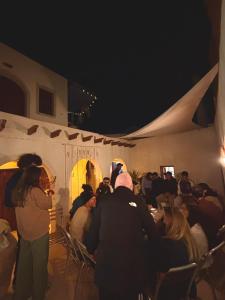 a group of people sitting in a tent at night at Dar Hallouma - WostelDjerba community in Djerba