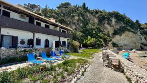 a row of blue chairs and a building at Fetsis Apartments in Agios Nikitas