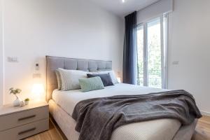 ein weißes Schlafzimmer mit einem großen Bett und einem Fenster in der Unterkunft Lamagia in Bologna