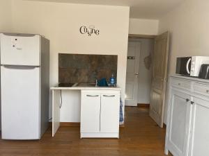 a kitchen with white cabinets and a white refrigerator at Studio in Brando