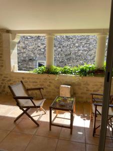 a room with two chairs and a table and a stone wall at la capelette in Céreste +6 photos