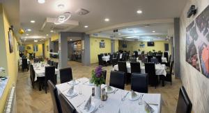 a dining room with white tables and black chairs at Mirocki-Raj in Miroč