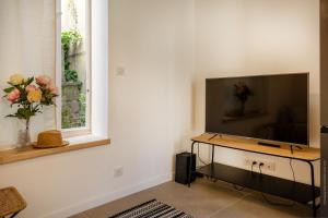 a living room with a flat screen tv and a window at Casa Campinchi in Bastia