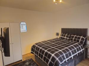 a bedroom with a bed with a black and white checkered blanket at wyvis stays in Inverness