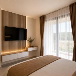 a bedroom with a bed with a flat screen tv at Visnjeva Gardens in Višnjevo