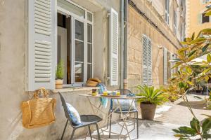 a patio with a table and chairs and a window at Casa Campinchi in Bastia