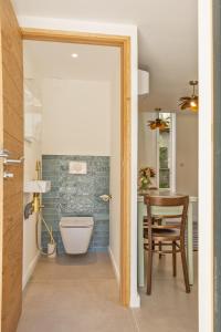 a bathroom with a toilet and a table and a chair at Casa Campinchi in Bastia +15 photos