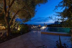 a backyard with a swimming pool at night at Vila Veslo in Begovići