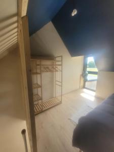 a bedroom with a blue ceiling and a book shelf at Maisonnette nature et sérénité in Évran