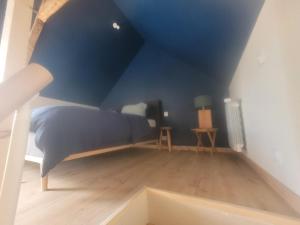 a bedroom with a bed with a blue ceiling at Maisonnette nature et sérénité in Évran
